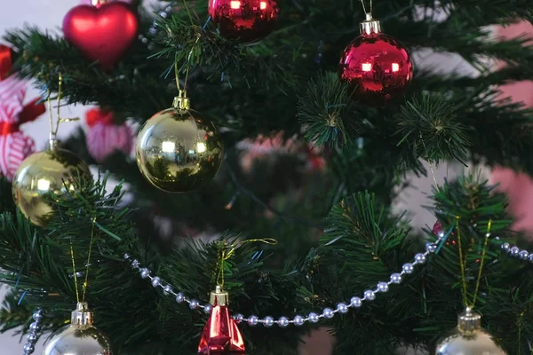圣诞树树枝上的红色、金色和银色珠子的圣诞装饰品. — 图库照片