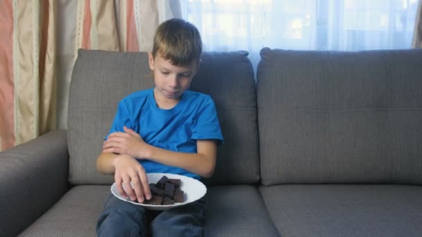 Jongen met karakter. Tiener kijkt snoepjes. Concept van ongezond eten. — Stockvideo