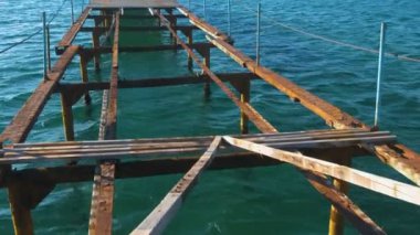 Denizin üzerinde eski ahşap iskele yok. Paslı çelik çerçeve, onarım.