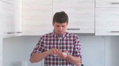 Adam hapları, vitamin alır ve onları su ile içecekler.