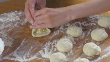 Kadının elleri yapar bir pasta pirinç ve yumurta Maya hamur ürünleri ile mutfak masasında.