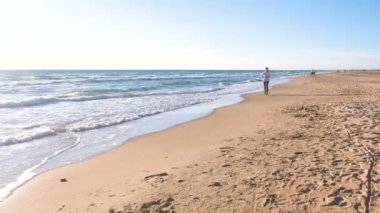 Kadın güzel dalgaları ile kum sahilde koşu.