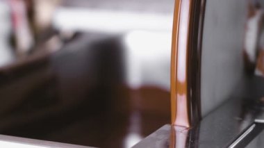 Sıcak sıvı makine temperleme çikolatada çikolata. Yakın çekim görünümü. Bulanıklık.