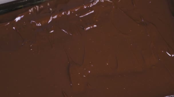 Flüssige Schokolade ein Backblech. Füllung für Schokoladenbonbons. Produktion von Schokoladenbonbons. — Stockvideo