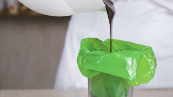 Verter chocolate líquido en la bolsa de pastelería . — Vídeo de stock