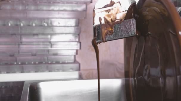 Warme vloeistof chocolade in chocolade ontlaten machine. Close-up weergave. Productie van chocolade candys. — Stockvideo