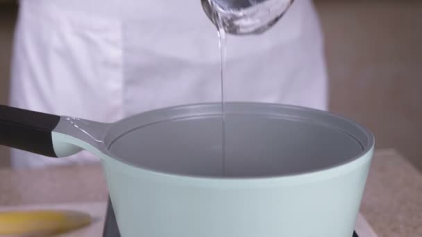 Cuire verser la glycérine liquide dans la casserole pour réchauffer. Vue rapprochée . — Video