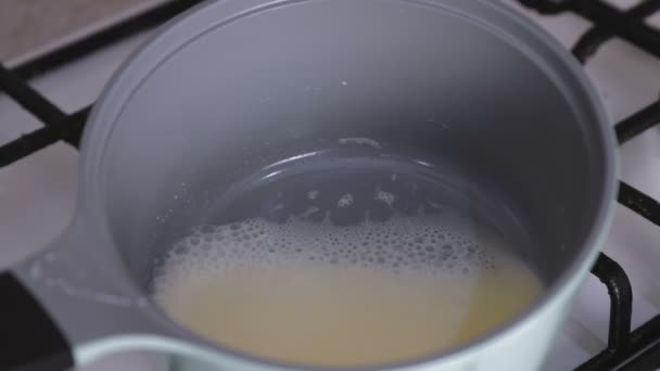 Crème bouillante dans une casserole sur une cuisinière à gaz . — Video