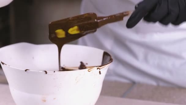 Cook mix vloeibare donkere chocolade in een witte kom. Close-up weergave. — Stockvideo