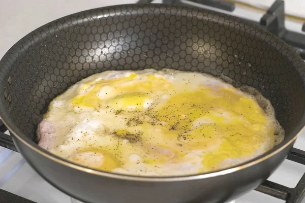Приготовление яичницы с колбасой в сковороде на газовой плите . — стоковое фото