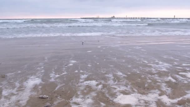 Büyük fırtınalı dalgalar deniz. İskele, kumlu plaj gün batımında güzel deniz manzarası. — Stok video