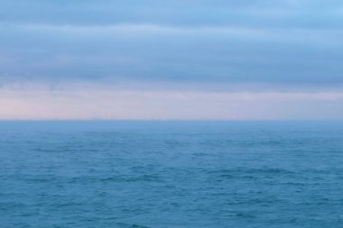 Pembe günbatımı ve mavi bulutlar güzel deniz manzarası. Sakin deniz.