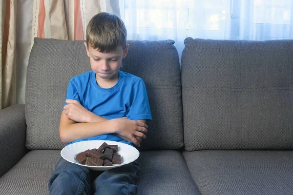 Парень с характером. Подросток смотрит на конфеты. Концепция нездорового питания . — стоковое фото