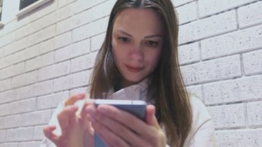 Kadın oturuyor ve biri kafede bekliyorum cep telefonunda bir mesaj yazarak