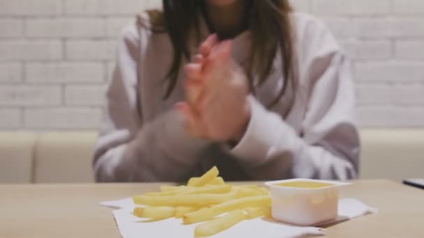 Woman is eating French fries with cheese sauce in cafe. Close-up hands. — Stock Video