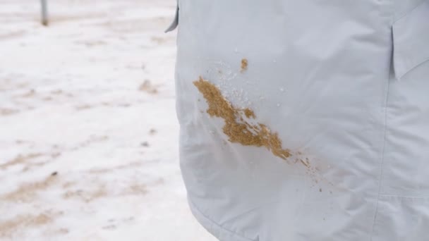 Zand van vuil en sneeuw op een witte womens jas. — Stockvideo