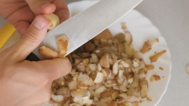 Mans rukou je loupání brambor s kuchyňským nožem. — Stock video