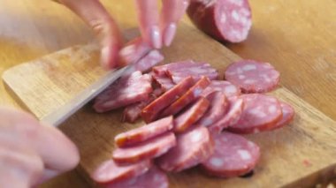 Tütsülenmiş sosis dilimleri ve parçalar için kesme womans yakından görmek eller.