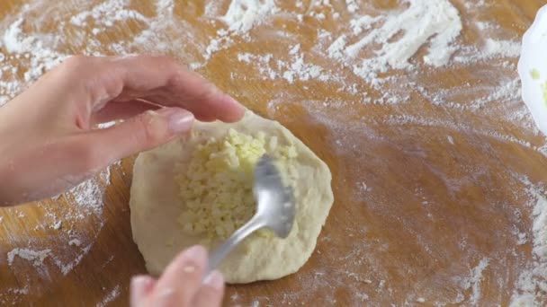 Womans kezébe teszi a rizs és a tojás a tészta gombás pite a konyhaasztalon. Close-Up Nézd. — Stock videók