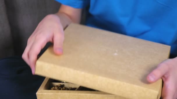 Pojke öppnar en låda med choklad godis och äter cocolates. Närbild choklad. — Stockvideo