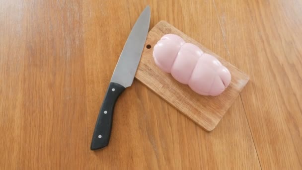 Salchichas hervidas, cuchillo y tabla de madera sobre la mesa . — Vídeos de Stock