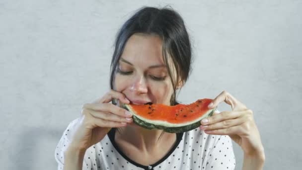 Hongerige vrouw eet snel een watermeloen. — Stockvideo