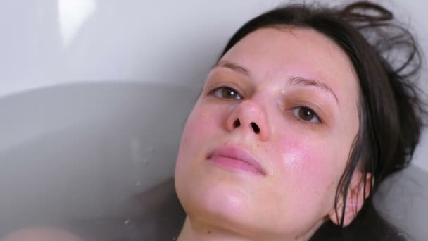 La mujer se sumerge en el agua del baño. Primer plano de la cara . — Vídeos de Stock