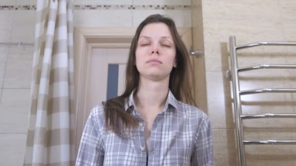 Moe vrouw wakker geworden in de badkamer kijken naar haar spiegelbeeld in de marror en probeert zich in orde te brengen. — Stockvideo