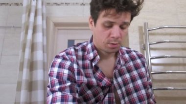 Çılgın uyandı adam banyoda bir kalıntı ile kendini sırada koyar, yamalar gözlerinin altında sopa.