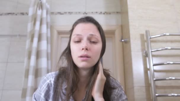 Woken trött kvinna i badrummet luktar själv på kinderna att vakna upp. — Stockvideo