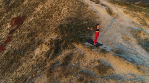 Bela vista da mulher fazendo ioga alongamento na montanha com vista para o mar ao pôr do sol. Alongar as mãos . — Vídeo de Stock