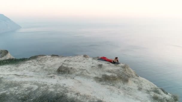 Femme faisant du yoga Adhu Mukha Svanasana, Ustrasana Pose sur le sommet de la montagne au coucher du soleil avec vue sur la mer. Belles images aériennes . — Video