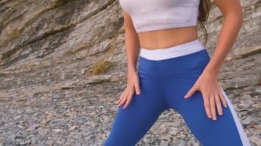 Kız işi sırasında nefes egzersizleri kaya zemin üzerine bodyflex ağız kavgası. Yakın çekim göbek ve vücut, tanınmaz.