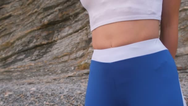 Flachen Bauch Mädchen während Zwerchfell Atemübungen Bodyflex auf dem Felsen Hintergrund. Bauch aus nächster Nähe. — Stockvideo