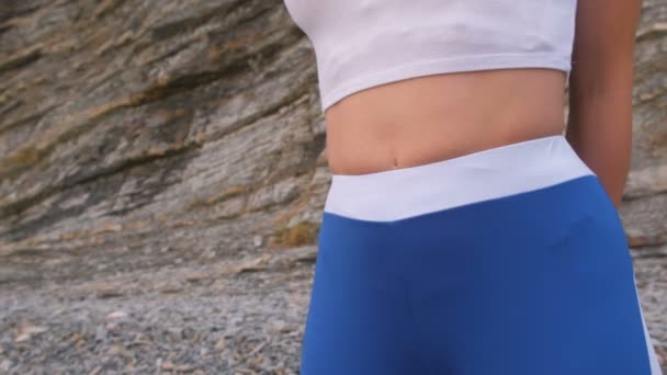 Flat belly girl during diaphragmatic breathing exercises bodyflex on the rock background. Belly close-up view. — Stock Video