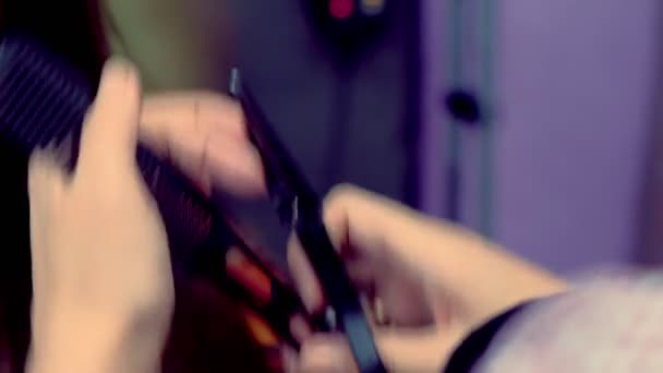 Парикмахер стрижет кончики женских волос горячими ножницами . — стоковое видео