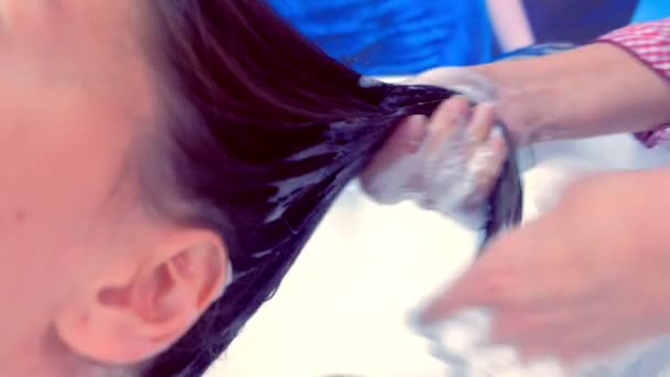 Peluquería clientes de lavado de cabello en salón de belleza en fregadero . — Vídeos de Stock