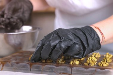 Fırıncılar eller ceviz yarısı formlarda çikolata şeker koymak.