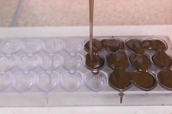 Виготовлення саморобних пралінових цукерок, заливка шоколаду формами . — стокове фото