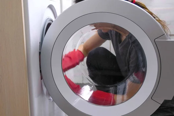 Bir çamaşır makinesi sünger ile kırmızı lastik eldiven kadında yıkıyor. — Stok fotoğraf