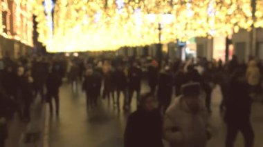 Altın Noel ışıkları süslemeleri ile sokakta yürüme millet, arka plan bulanıklık.
