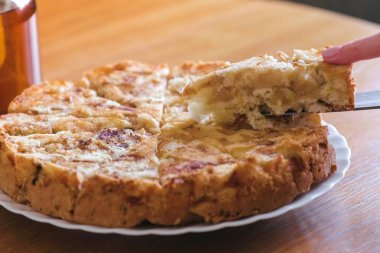 Yakın çekim womans eller plaka ev yapımı elma pasta bir dilim alır. Masanın üzerine çaydanlık.