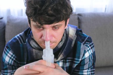 Hasta adam için burun spreyi meme aracılığıyla teneffüs edilmesi. Yakın çekim yüz, önden görünüm. Nebulizatör ve astım tedavisi için kullanın.