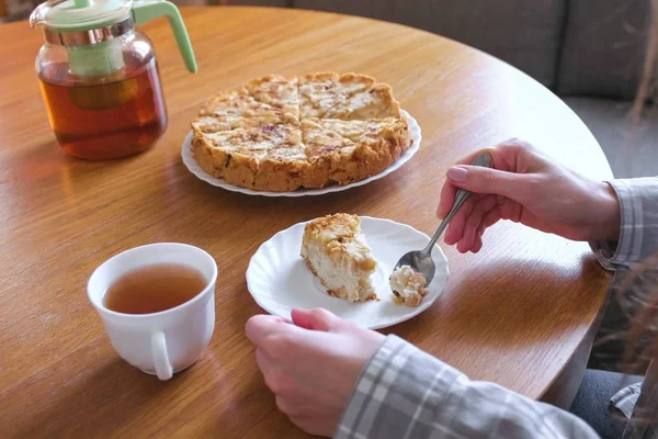 Femme mange de la tarte aux pommes maison et boit un thé. Gros plan des mains . — Photo