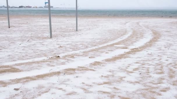 Hermosa vista de la arena y la tormenta de nieve en la playa en invierno. Puerto marítimo . — Vídeos de Stock