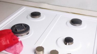 Kırmızı lastik eldiven yıkar kirli gaz sobası bir fırça ve sünger ile kadının eller.