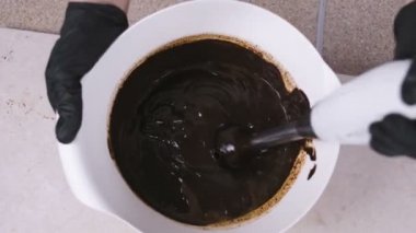 Blender ile sıvı koyu çikolata beyaz bir kase içinde karıştırın. Yakın çekim yakışıklı.