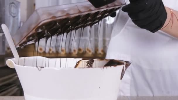 Processo di versamento di eccessi di cioccolato da forme di cottura in ciotola bianca. Concetto di dolci da cucina . — Video Stock