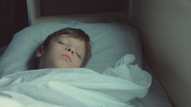 Çocuk erken sabah, yüz yakın çekim hareket eden bir trenin arabaya uyuyor.