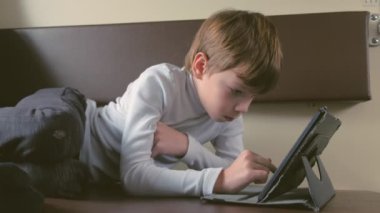 Çocuk trende bir tablet alt rafta döşeme ikinci sınıf bir satır boşluğu içinde oynuyor.